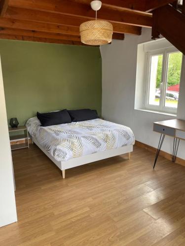 - une chambre dotée d'un lit avec un mur vert dans l'établissement Le Nid Familial, Maison cosy entre terre et mer, à Saint-Germain-de-Tournebut