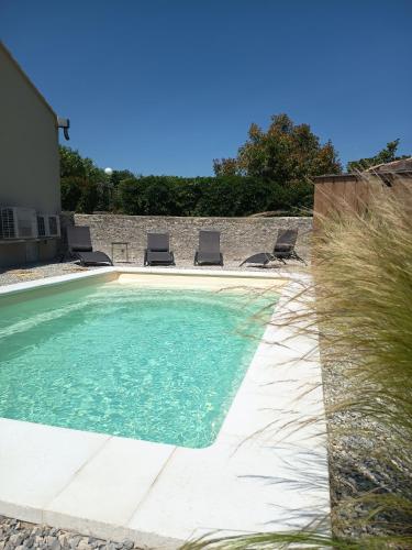 une piscine avec des chaises dans une cour dans l'établissement L'ombre du tilleul, à Saint-Maurice-sur-Eygues