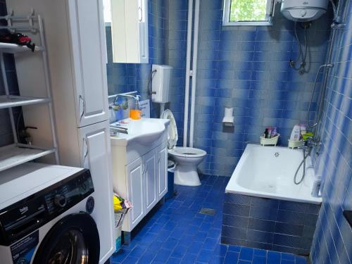 a blue tiled bathroom with a toilet and a sink at Vila Marija in Podgorica