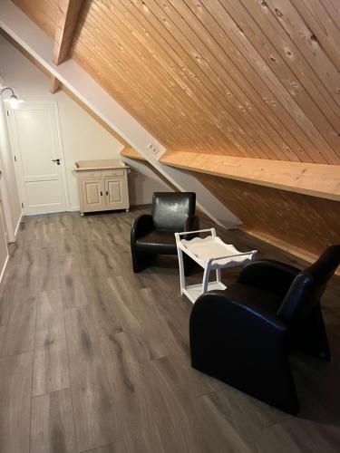 a living room with two chairs and a table at Christinahoeve Logies in Boskoop