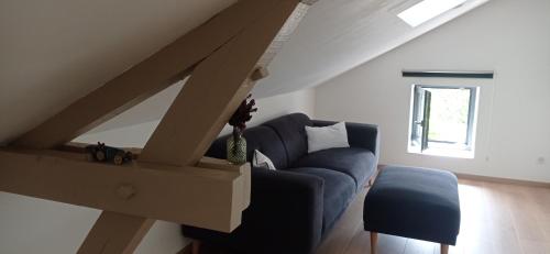 a living room with a blue couch and a window at Le numéro 5 in Bar-le-Duc
