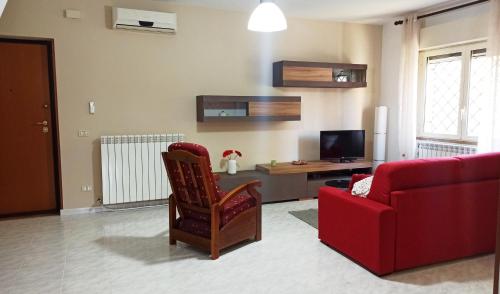 a living room with a red couch and a red chair at Appartamento Teresina in Atina