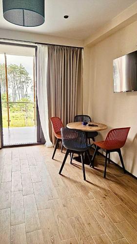 a dining room with a table and chairs and a patio at Terrace Kapro-one in Itʼkhvisi