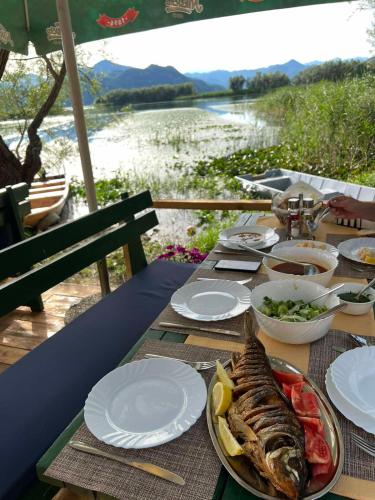 a table with a plate of food with a fish on it at Apartman Skadarsko jezero bay in Vranjina