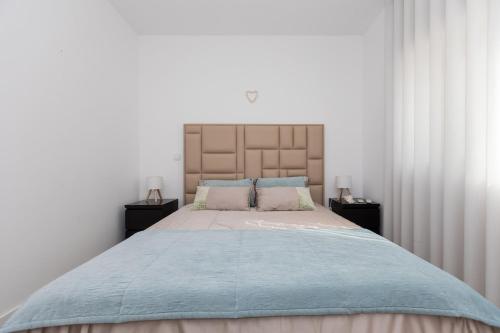 een slaapkamer met een groot bed met twee nachtkastjes bij Casa Nau - with pool and sea view in Sesimbra