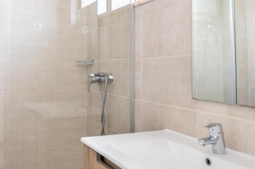 a bathroom with a shower with a sink and a mirror at Cabanas de Tavira - Studio in Cabanas de Tavira