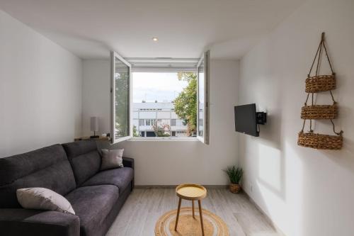 un salon avec un canapé et une fenêtre dans l'établissement Le Manoë- Proche GareSt Nazaire, à Saint-Nazaire