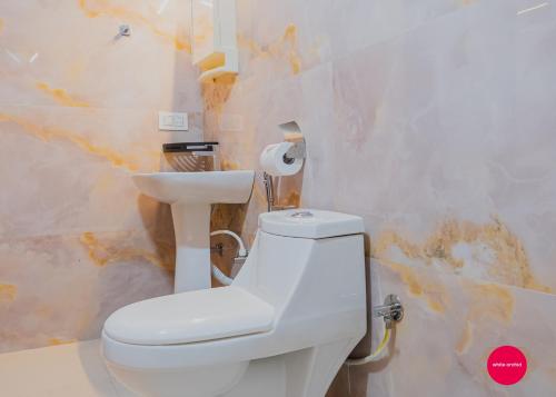 a bathroom with a white toilet and a sink at White Orchid in Kalimpong