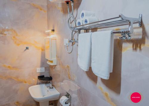 a bathroom with a sink and a toilet and towels at White Orchid in Kalimpong