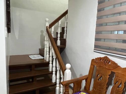 a wooden staircase with a wooden chair next to it at MNM Apartments cruz in Tanauan