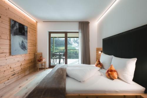 a bedroom with a bed and a balcony at Archehof Hochzirm Lodge Johanna in Campo Tures