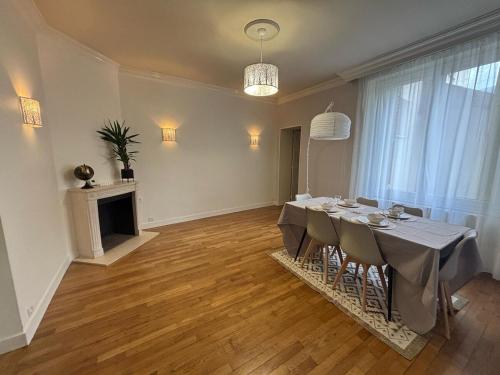une salle à manger avec une table et une cheminée dans l'établissement Grand T3 90m2 Haussmanien avec suite en centre ville et parking TOUT inclus, à Orléans