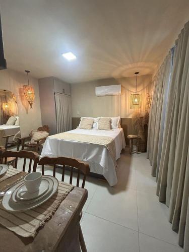 a bedroom with a bed and a table and chairs at Aurea Bauten in João Pessoa