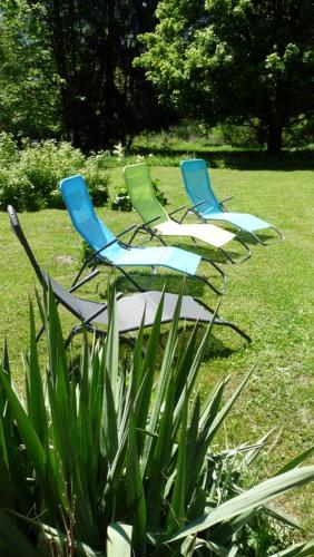 a group of chairs sitting in the grass at Le mas des Alberges in Le Bourg-dʼOisans