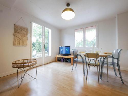 une salle à manger avec une table, des chaises et une télévision dans l'établissement Le nid de la Canopée, à Montpellier