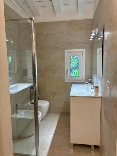 a bathroom with a sink and a tub and a toilet at Residenza Porto Rotondo in Porto Rotondo