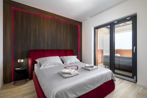 a bedroom with a large bed with a red headboard at Luxury Penthouse Viki with seaview in Umag