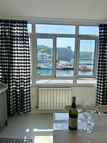 a kitchen with a window with a bottle of wine on a counter at La Rula in Luarca