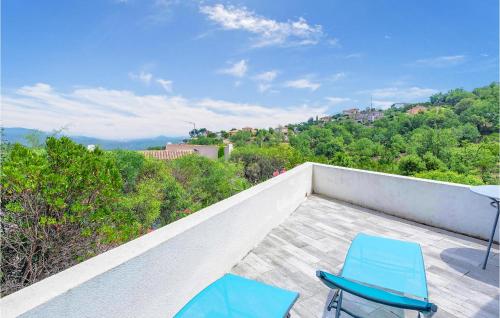 - deux chaises bleues assises sur le balcon d'une maison dans l'établissement Nice Home In Les Adrets-De-Lestére, à Les Adrets-de-l'Estérel