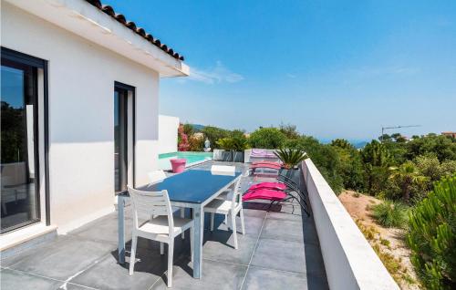 un patio avec une table et des chaises sur un balcon dans l'établissement Nice Home In Les Adrets-De-L'estére, à Les Adrets-de-l'Estérel