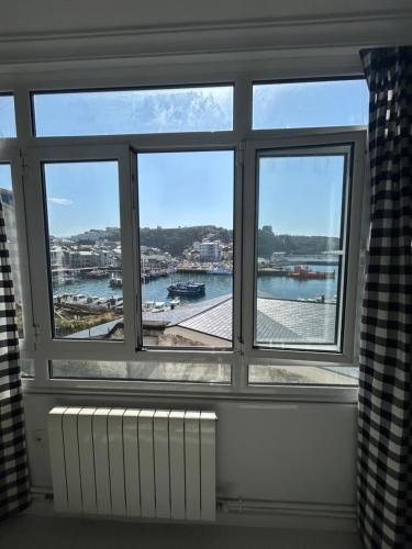 a room with a window with a view of a harbor at La Rula in Luarca