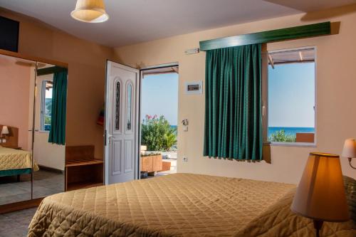 a bedroom with a bed and a view of the ocean at Limanaki Apartments in Faliraki