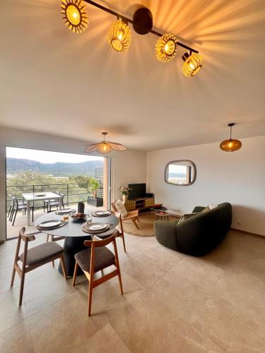 un salon avec une table et des chaises dans l'établissement Appartement CASA VISTA splendide vue sur le Golfe, à Porto-Vecchio
