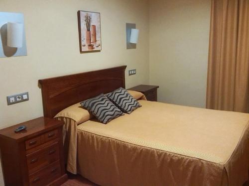 a hotel room with two beds and a dresser at Hotel Reina Isabel in Medina del Campo