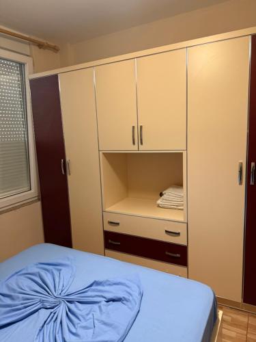 a bedroom with a bed and white cabinets at Studio holidays in Shëngjin