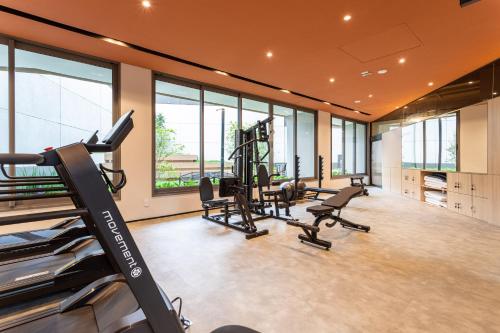 Un gimnasio con cintas de correr y elípticas en una habitación con ventanas. en Charlie Nik Perdizes, en São Paulo