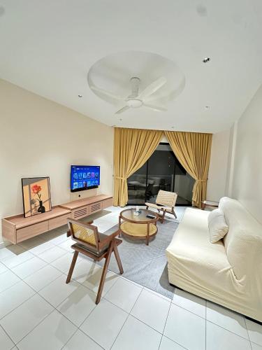 un soggiorno con un divano e una TV di NEWLY RENOVATED Comfy Beachfront View At Seri Bulan Port Díckson a Port Dickson