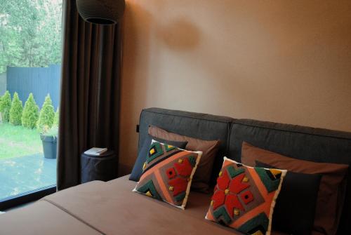 a bedroom with a bed with pillows and a window at Richkas Chalet котедж з чаном-джакузі in Slavske