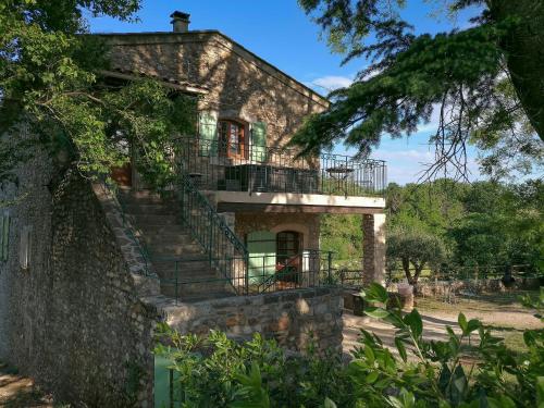 - un vieux bâtiment en pierre avec des escaliers et un balcon dans l'établissement Les Cezennes, à Saint-Ambroix