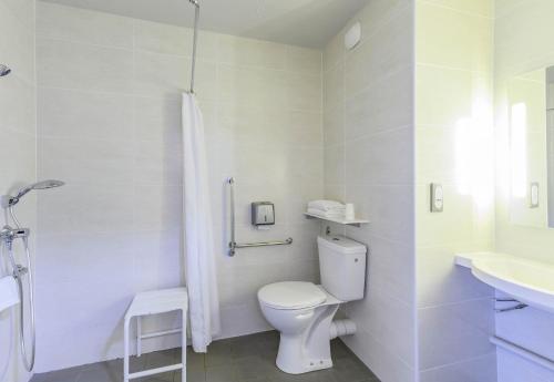 a white bathroom with a toilet and a sink at B&B HOTEL Orange in Orange
