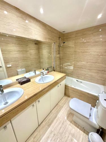 a bathroom with two sinks and a toilet and a tub at La Cala de Mijas, groundfloor 2 bed apartment steps away from the beach in Mijas Costa