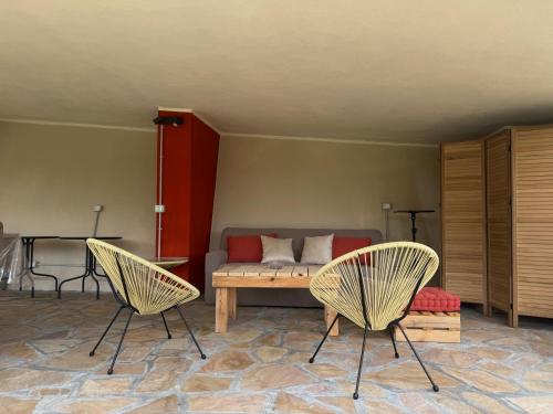 a living room with two chairs and a bed at Ligo in Villanova dʼAlbenga