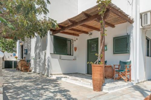 a white house with a wooden pergola at Mouria Studio A in Kithnos
