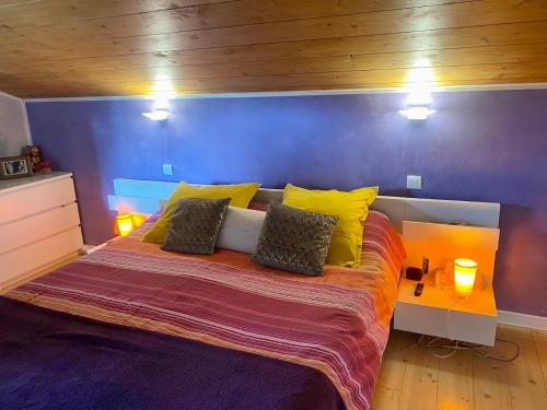 une chambre avec un grand lit avec des oreillers jaunes dans l'établissement Chambre Viviane, à Néant-sur-Yvel