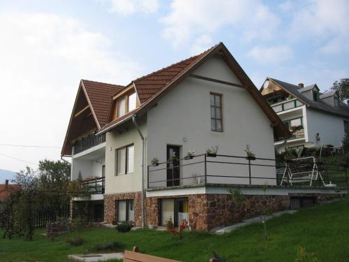 a large white house with a brown roof at Kéktúrás-Tóra Nyíló Badacsonyi privát bérlemény in Badacsonytomaj