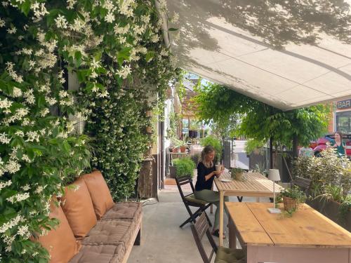 a woman sitting at a table in a garden at B&B La Volpina in Rimini