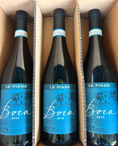 three bottles of wine in a cardboard box at CASCINA DOMINA in Gassino Torinese