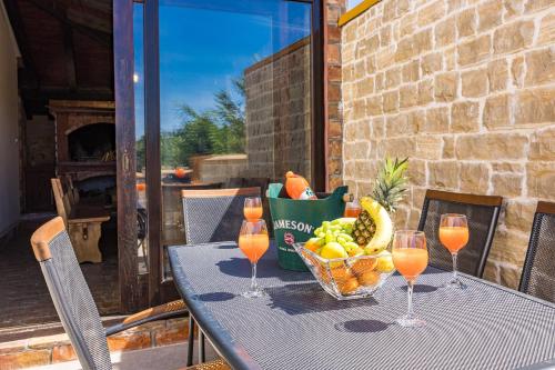 a table with a basket of fruit and wine glasses at Holiday Home Mario in Pula