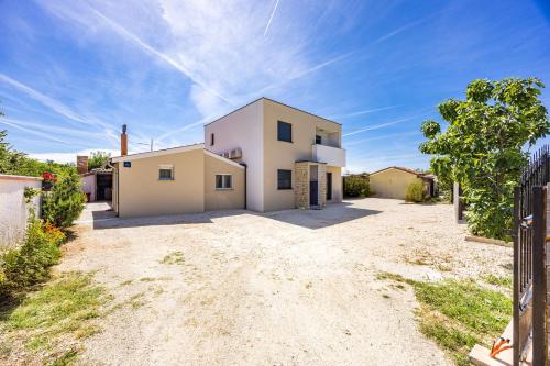 a white house with a gate in the driveway at Holiday Home Mario in Pula