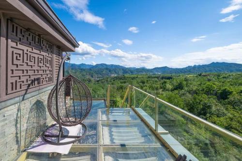 a balcony with chairs and a view of the mountains at Gubei Water Town Landscape Villa in Miyun