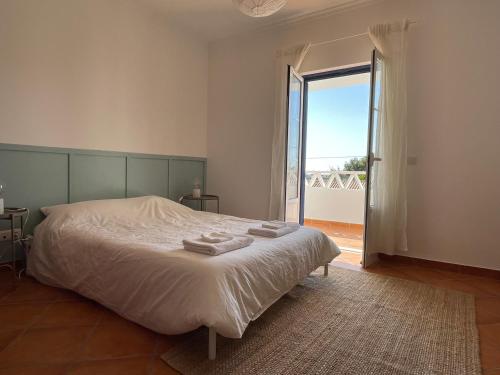 a bedroom with a bed with towels on it at Casa Manel in Odemira
