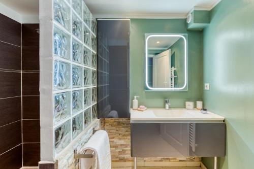une salle de bain avec un lavabo et un miroir dans l'établissement Demeure Domaine du Soleil, au Lavandou