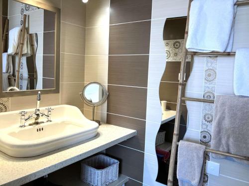 une salle de bain avec un lavabo, un miroir et des serviettes dans l'établissement Anemone - Saint Hilaire de Riez, à Saint-Hilaire-de-Riez