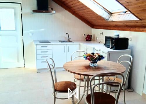 a kitchen with a table and chairs and a kitchen with a window at MyStay - Casa Sete Lano in Pedrógão