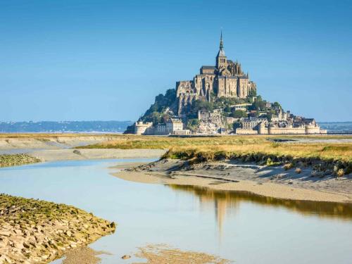 une île avec un château sur une colline avec une rivière dans l'établissement Auberge de Jeunesse HI Genêts, à Genêts