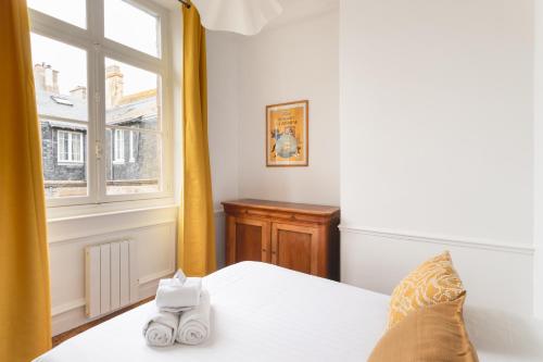 une chambre avec un lit avec des serviettes blanches dessus dans l'établissement L'Epervier - 200m de la plage, à Saint-Malo